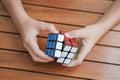 Portrait of cute kid boy holding Rubik`s cube and playing with it at the desk. Rubik`s cube in child`s hands. Banner. Royalty Free Stock Photo