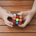 Portrait of cute kid boy holding Rubik`s cube and playing with it at the desk. Rubik`s cube in child`s hands. Banner. Royalty Free Stock Photo