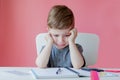 Portrait of cute kid boy at home making homework. Little concentrated child writing with colorful pencil, indoors. Elementary