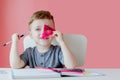 Portrait of cute kid boy at home making homework. Little concentrated child writing with colorful pencil, indoors. Elementary Royalty Free Stock Photo