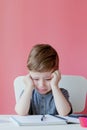 Portrait of cute kid boy at home making homework. Little concentrated child writing with colorful pencil, indoors. Elementary