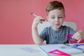 Portrait of cute kid boy at home making homework. Little concentrated child writing with colorful pencil, indoors. Elementary Royalty Free Stock Photo