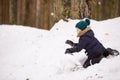 Portrait of cute kid boy making snowman outdoors. Child playing with snow in the forest on a winter day. Lifestyle concept Royalty Free Stock Photo