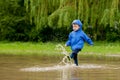 Portrait of cute kid boy playing with handmade ship. kindergarten boy sailing a toy boat by the waters` edge in the park Royalty Free Stock Photo