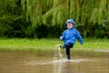 Portrait of cute kid boy playing with handmade ship. kindergarten boy sailing a toy boat by the waters` edge in the park Royalty Free Stock Photo