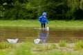 Portrait of cute kid boy playing with handmade ship. kindergarten boy sailing a toy boat by the waters` edge in the park