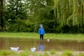 Portrait of cute kid boy playing with handmade ship. kindergarten boy sailing a toy boat by the waters` edge in the park Royalty Free Stock Photo