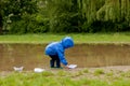 Portrait of cute kid boy playing with handmade ship. kindergarten boy sailing a toy boat by the waters` edge in the park Royalty Free Stock Photo