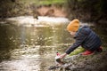 Portrait of cute kid boy playing with handmade ship. kindergarten boy sailing a toy boat by the waters` edge in the park Royalty Free Stock Photo