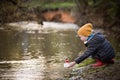 Portrait of cute kid boy playing with handmade ship. kindergarten boy sailing a toy boat by the waters` edge in the park Royalty Free Stock Photo