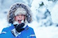 Portrait of cute kid boy trying to eat snow outdoors. Child having fun in a winter park Royalty Free Stock Photo