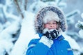 Portrait of cute kid boy trying to eat snow outdoors. Child having fun in a winter park Royalty Free Stock Photo