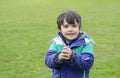 Portrait of cute kid shivering in cold weather and rubbing hands while standing in the grass field, Selective focus of Child boy Royalty Free Stock Photo