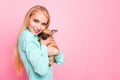 Portrait of cute lady with her purebred doggy cuddling looking wearing teal turquoise shirt isolated over pink