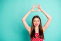 Portrait of cute lady smiling showing heart shaped sign wearing polka dot dress skirt isolated over teal turquoise Royalty Free Stock Photo