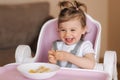 Portrait of cute laughing little girl in hight chair Royalty Free Stock Photo