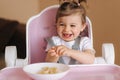 Portrait of cute laughing little girl in hight chair Royalty Free Stock Photo