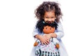 Portrait of a cute little african american girl hugging doll, isolated on white background Royalty Free Stock Photo