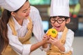 Portrait cute little Asian happy boy chef interested in cooking with mother funny in home kitchen. People lifestyles and Family.