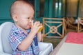 Portrait of Cute little Asian 18 months / 1 year old baby boy child drinking fruit juice in a glass Royalty Free Stock Photo
