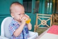 Portrait of Cute little Asian 18 months / 1 year old baby boy child drinking fruit juice in a glass Royalty Free Stock Photo