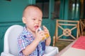 Portrait of Cute little Asian 18 months / 1 year old baby boy child drinking fruit juice in a glass Royalty Free Stock Photo