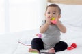 Portrait of cute little baby girl sitting with cozy on bed at bedroom, happiness of toddler. Royalty Free Stock Photo