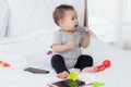 Portrait of cute little baby girl sitting with cozy on bed at bedroom, happiness of toddler, newborn 6-11 months. Royalty Free Stock Photo