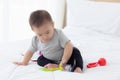Portrait of cute little baby girl sitting with cozy on bed at bedroom, happiness of toddler. Royalty Free Stock Photo