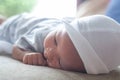 The portrait of cute little baby infant  boy wearing white hat lay to sleep prone on the bed Royalty Free Stock Photo