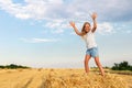 Portrait of cute little blond beautiful adorable cheerful caucasian kid girl enjoy sitting on hay stack or bale on Royalty Free Stock Photo