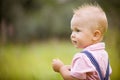 Portrait of cute little blond toddler boy looking into distance. Adorable child walking in the park on a sunny summer day. Royalty Free Stock Photo