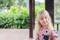 Portrait of a cute little blonde caucasian girl in the park