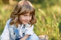 A portrait of a cute little boy with blue eyes and long blond hair sitting on a basket outside at sunset Royalty Free Stock Photo