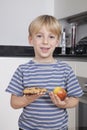 Portrait of cute little boy choosing between apple and chocolate chip cookie Royalty Free Stock Photo