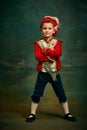 Portrait of cute little boy dressed up as medieval character, little prince and pageboy posing over dark vintage style Royalty Free Stock Photo