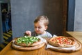 A portrait of cute little boy eating pizza in restaurant Royalty Free Stock Photo