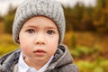 Portrait of a cute little boy in a gray hat and jacket with huge beautiful eyes