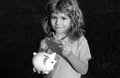 Portrait of cute little boy with piggy bank. Saving money concept. Kids with piggybank money box. Royalty Free Stock Photo