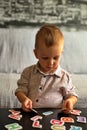 Little boy playing with letters and numbers on a table Royalty Free Stock Photo