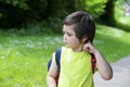 Portrait cute little boy scratching his itchy neck and looking down with thinking face, Kid get allergies while go out with school Royalty Free Stock Photo