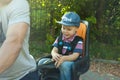 Portrait of Cute little caucasian 3 years old toddler baby boy child wearing cap in the seat bicycle behind father, outdoors