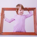 Portrait of cute little child girl extending rules beyond the frame. Freedom and development concept