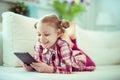 Portrait of cute little child girl with tablet at digital homeschooling Royalty Free Stock Photo