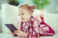 Portrait of cute little child girl with tablet at digital homeschooling Royalty Free Stock Photo