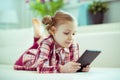 Portrait of cute little child girl with tablet at digital homeschooling Royalty Free Stock Photo