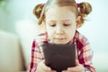 Portrait of cute little child girl with tablet at digital homeschooling Royalty Free Stock Photo