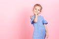 Portrait of cute little child girl wears blue dress while posing over pink studio background Royalty Free Stock Photo