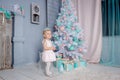 Portrait of a cute little european blond princess girl with a crown in a beautiful dress in a studio decorated in the Christmas