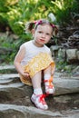 Portrait of a cute little girl on the background of nature. She`s sitting on the rocks Royalty Free Stock Photo